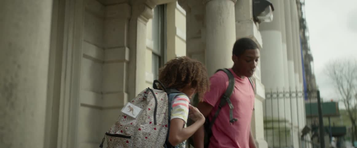 Two teenagers leave an apartment building