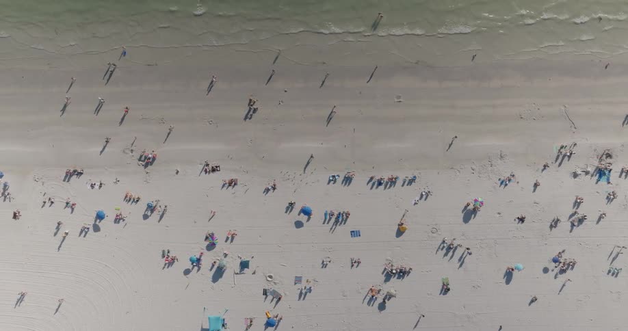 Pedestrians are enjoying the beach on a sunny day