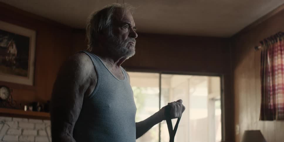 Elderly bearded man stretching his arms with an elastic band