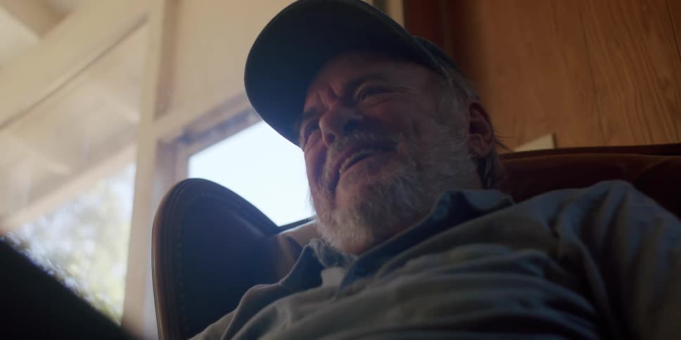 A man is sitting down and laughing