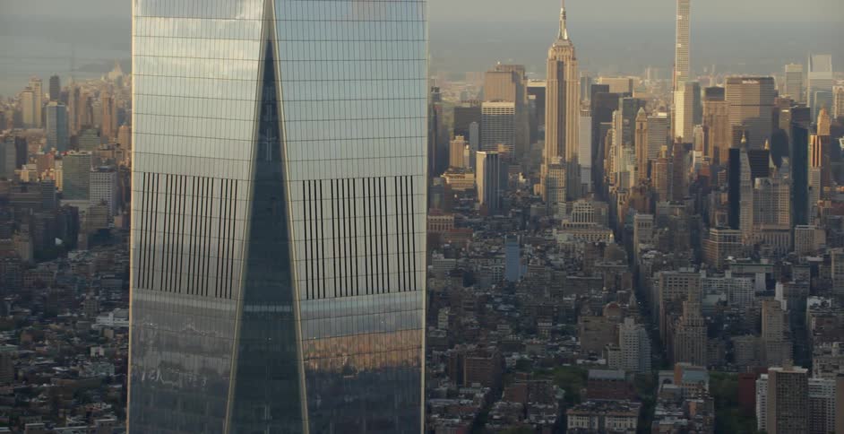 A very tall building has silver reflective siding