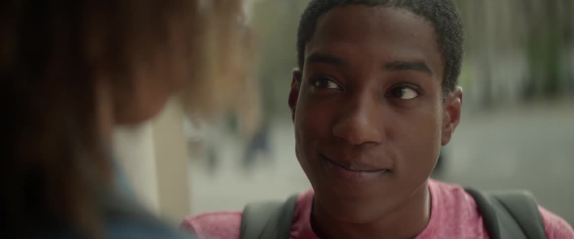 A boy is smiling while talking to a girl