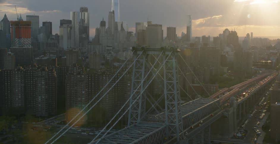 The sun shines down on a city bridge and skyscrapers