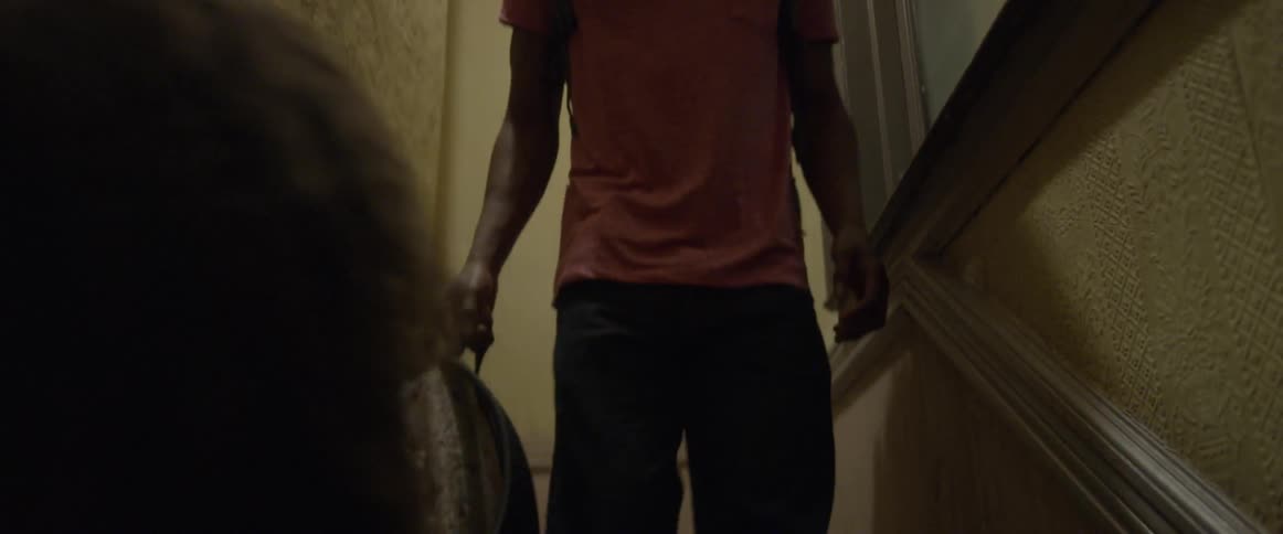Two people walk down apartment stairs
