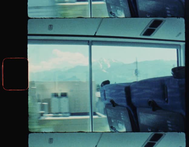 View from inside a moving transport with a city and mountains in the background