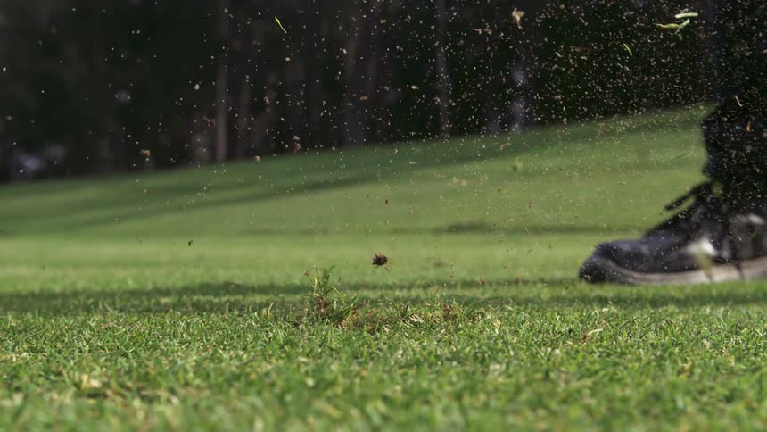 Golf ball being hit on a grass field