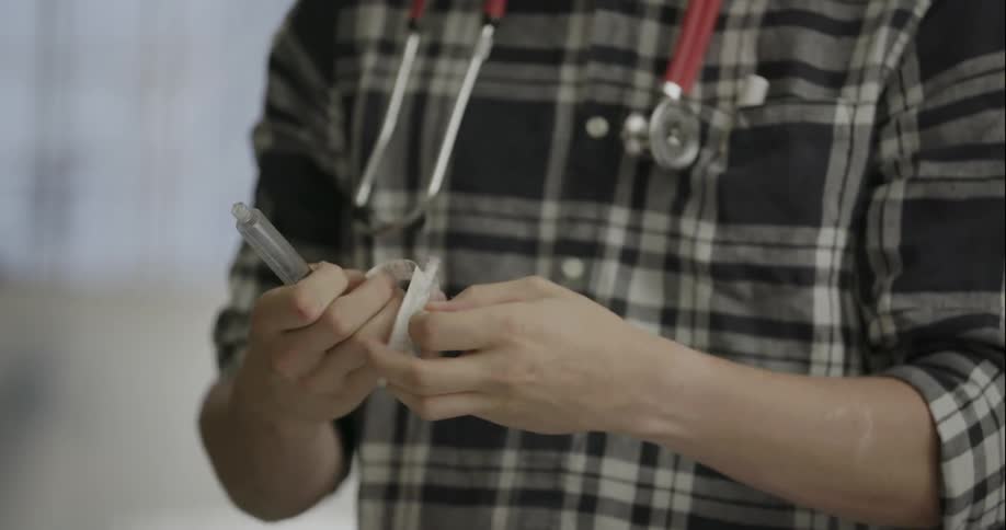 A nurse assembles a syringe