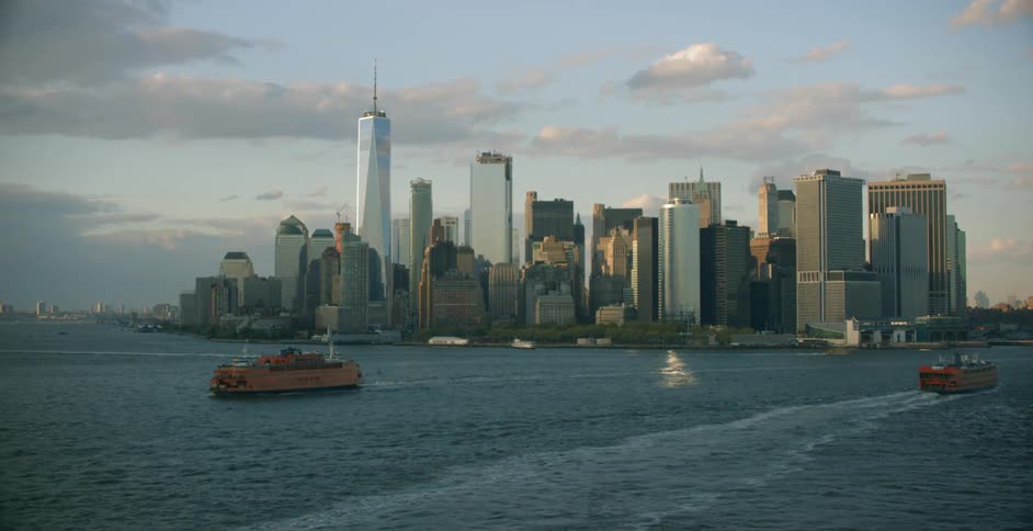 Ferry boats traveling over ocean water in front of new york city