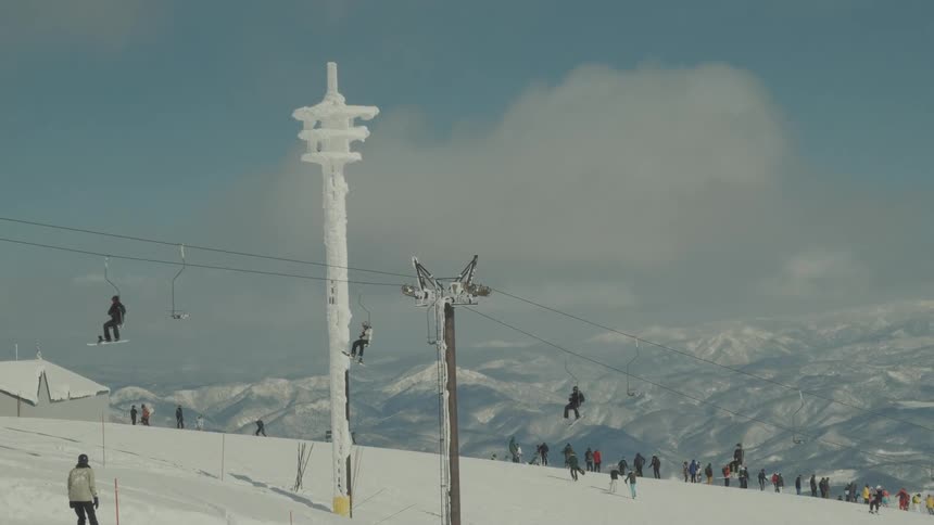 Tourists riding a cable car across a snowcovered mountain