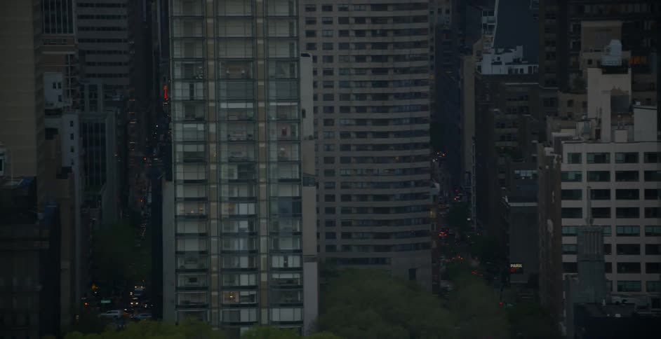 The tall buildings have heavy traffic in the streets