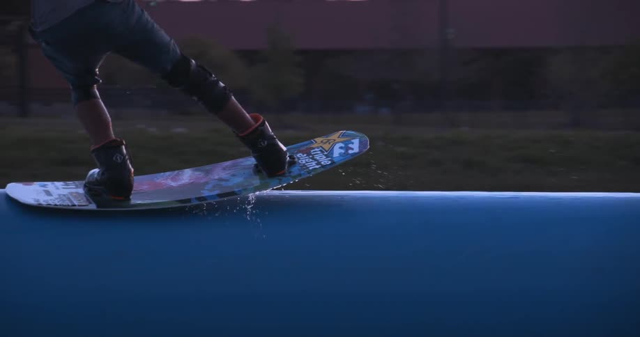 A wakeboarder jumps onto a floating platform