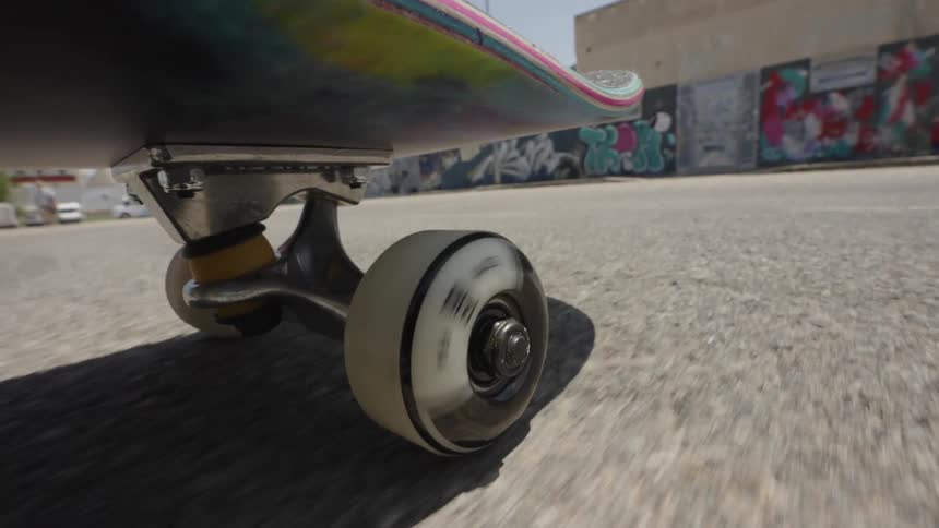 Close up of a skateboard moving down the street