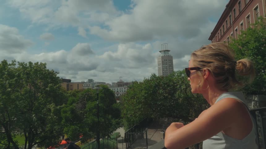 Woman in sunglasses enjoying the view of a city