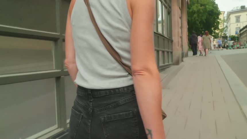 Woman with blonde hair walks down a city street