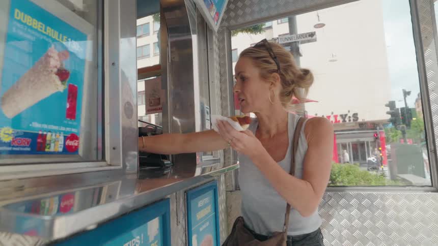 Woman getting a hot dog from a food truck