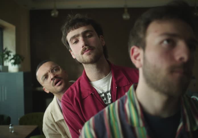 Men in a line looking forward with a curious tone
