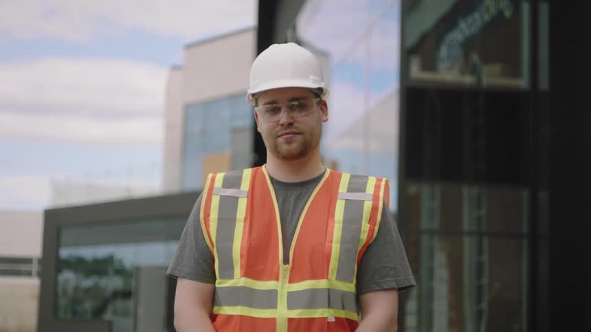 Portrait of a working man with a protective helmet in a signal vest