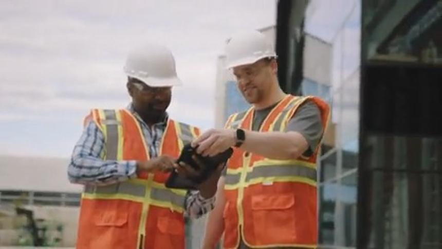 Two working men talking and interacting with a tablet