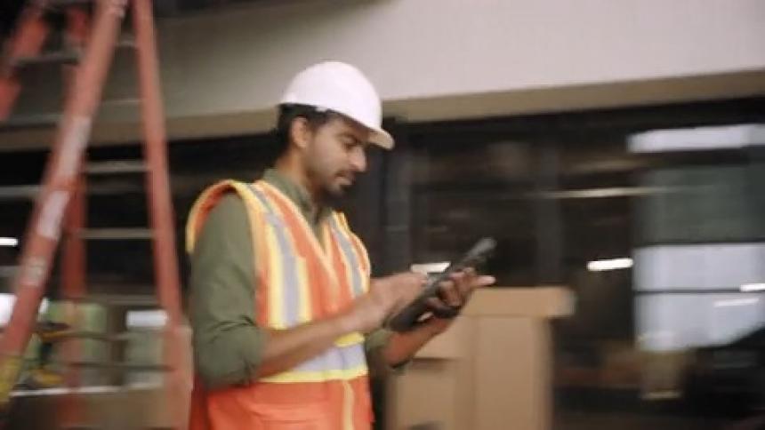Man at a construction site interacting with a tablet