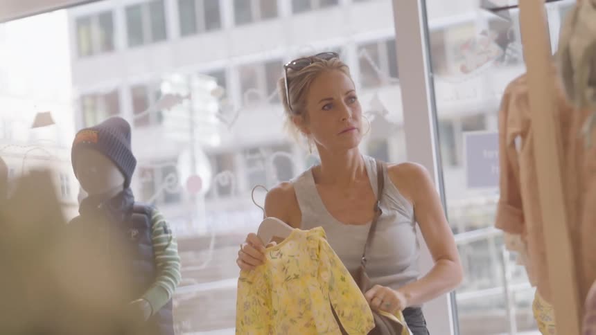 A woman in a shop choosing baby clothes