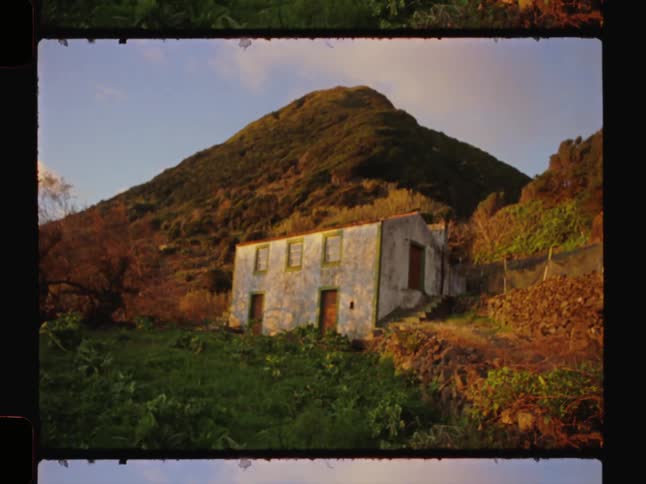 Isolated house in the middle of hills with mountains in the background