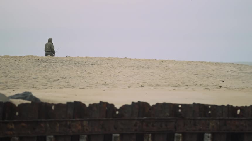 A man walks on a sandy hill