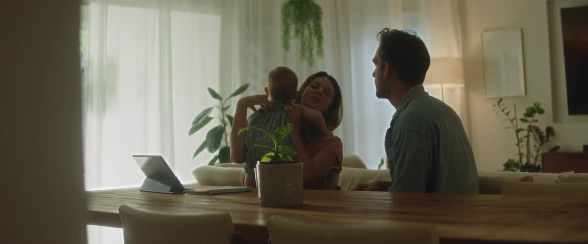 Happy family sits on the living room in front of a tablet