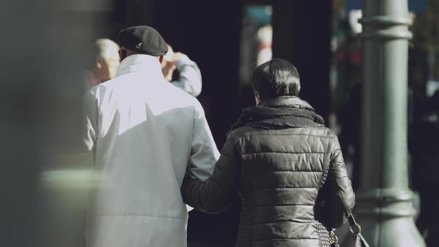 People in black and white jackets walk down the road