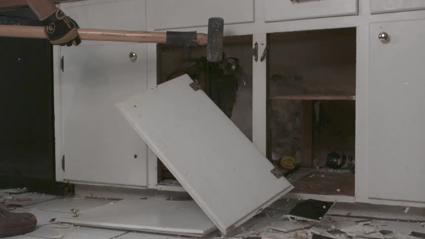 Person hitting cabinet with a hammer