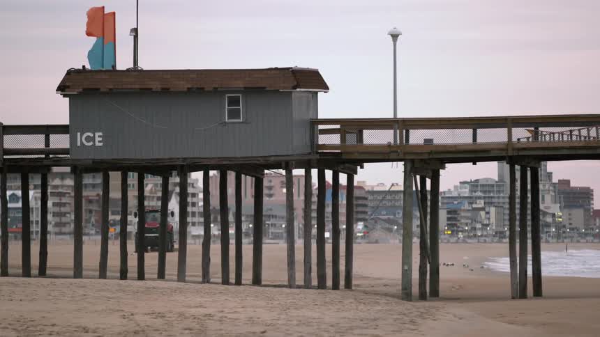 An empty dock above the beach on a cloudy day
