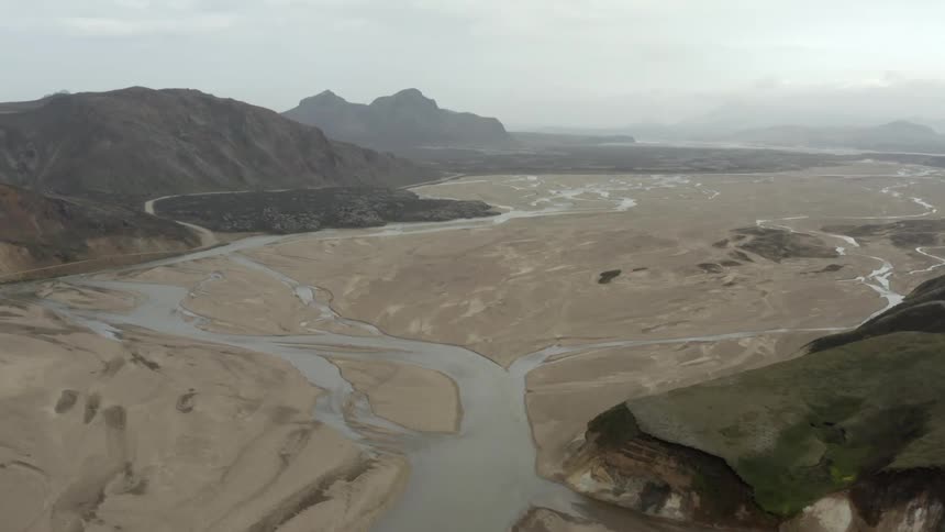 A shallow river crossing a sandy valley