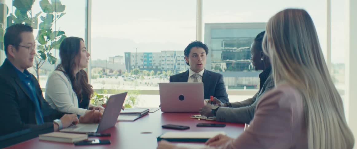 A group of office workers talk while in a meeting