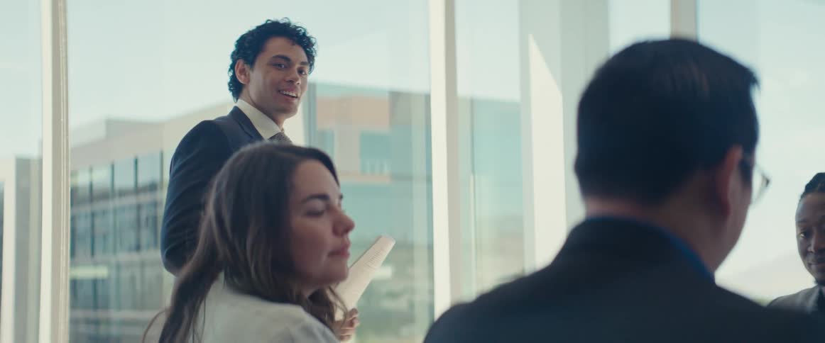 Man in suit standing talking in an office meeting