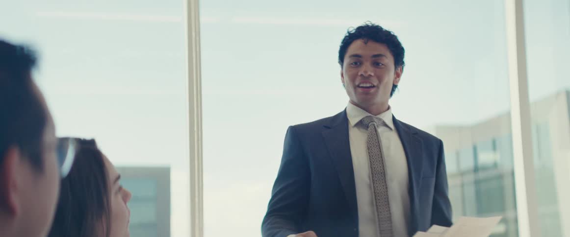A hispanic employee gives a presentation to his colleagues in an office