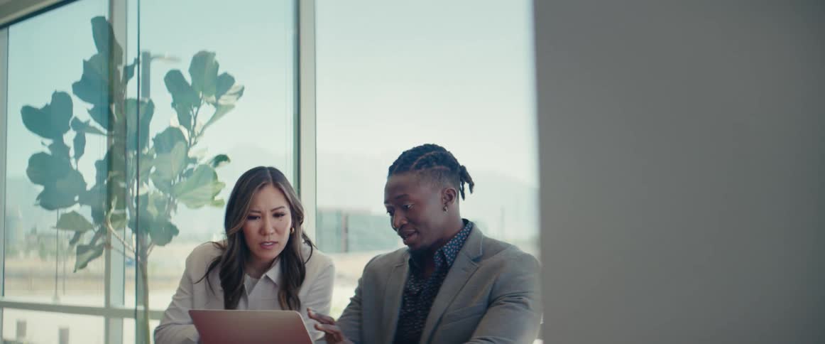 Woman talking to a man sitting in an office room