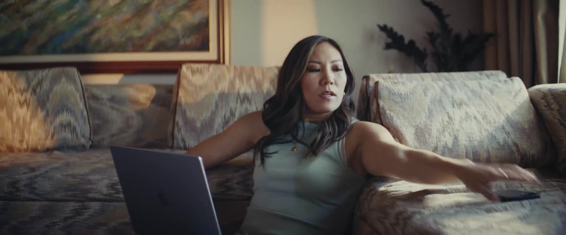 Woman sitting in living room checking time on her smartphone and quickly leaving