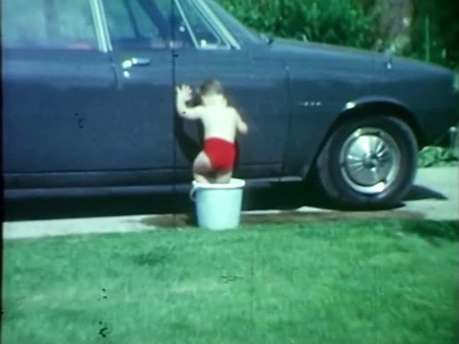 Toddler gets into bucket to wash car