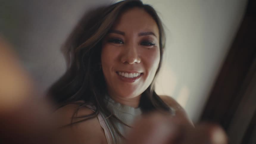 Woman smiles while scrolling on her device