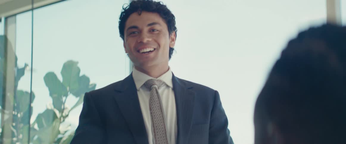 Smiling man standing talking and sitting with other people
