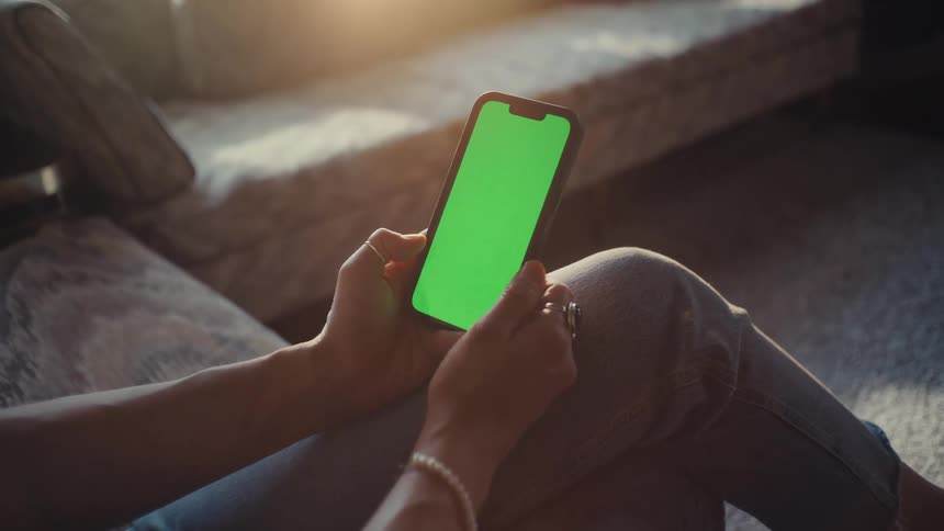 A woman is using her cell phone at home