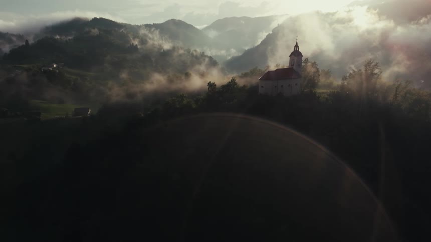 A church at the top of a foggy mountain