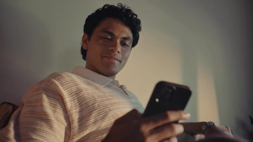 Man sitting interacting with a smartphone