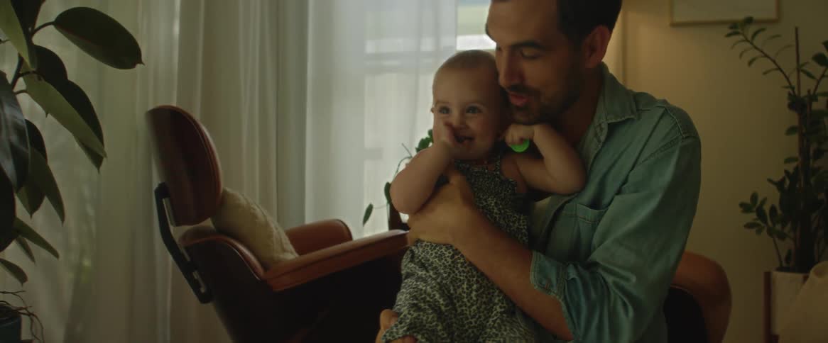 Man with a baby on his lap sitting in the living room