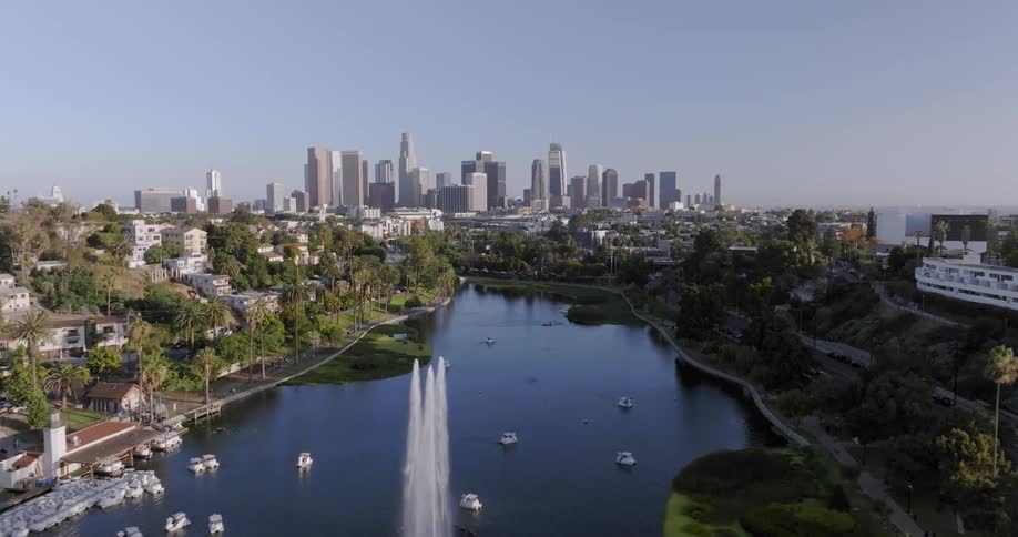 Aerial panorama of a forest with a lake surrounded by urban cities and skyscrapers on the horizon