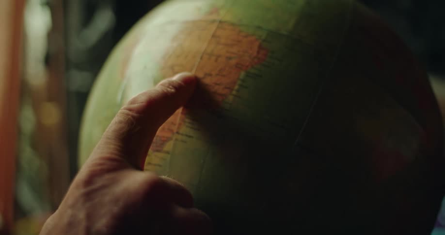 Persons finger being pointed at a scientific globe