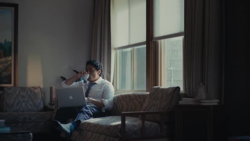 Man drinking water and checking the time and quickly leaving