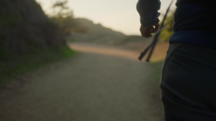 Closeup of a persons side walking on a mountain road
