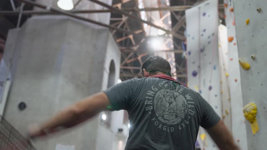 Man with ropes in a climbing training environment in the indoor shed