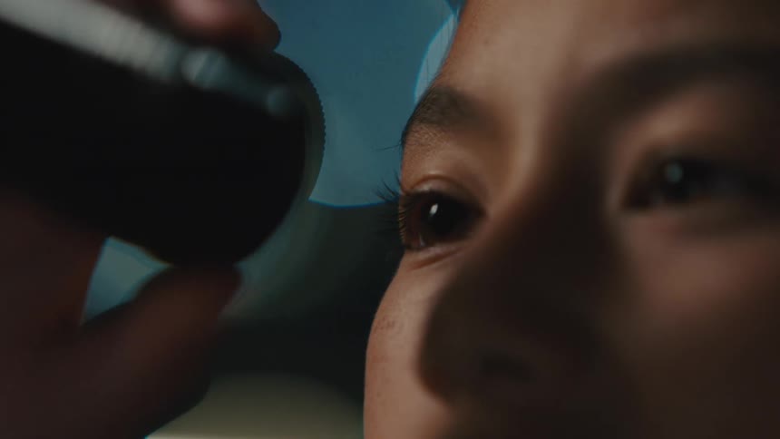 Close up of a young girls eyes as she looks through a scope