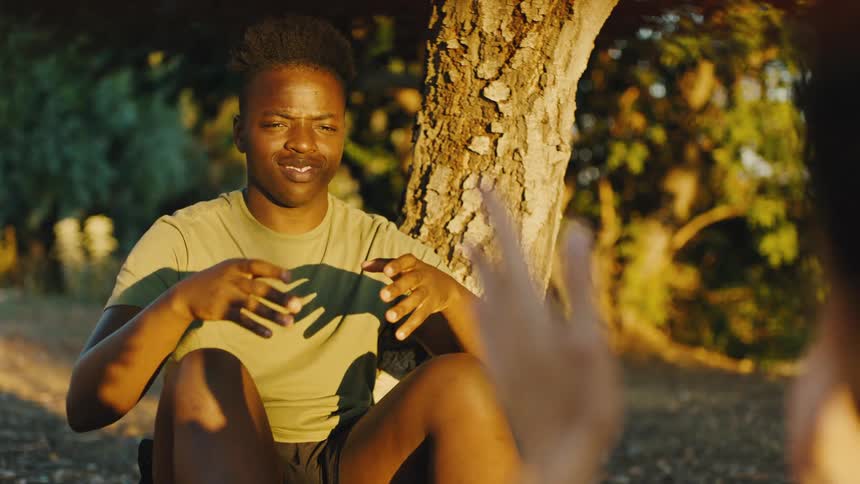 Teenager sitting under the tree talking